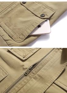 Vue macro du gilet de pêche kaki avec boutons métalliques et fermetures éclair solides