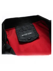 Detail view of black jacket collar with red honeycomb mesh lining and brand label