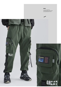 Dettaglio dei pantaloni cargo verde militare con tasche laterali e stampe grafiche