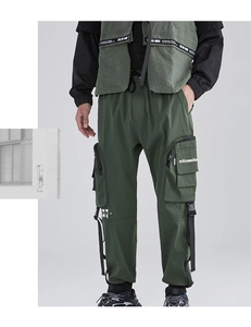 Dettaglio dei pantaloni cargo verde militare con tasche laterali e cinghie in nylon nero