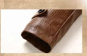 Macro detail of brown faux leather jacket cuff with crocodile texture and black button