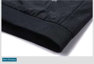 Detailed close-up of black camouflage jacket ribbed hem and honeycomb texture fabric