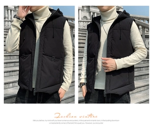 Close-up of black hooded padded vest featuring zipper closure and large utility pockets