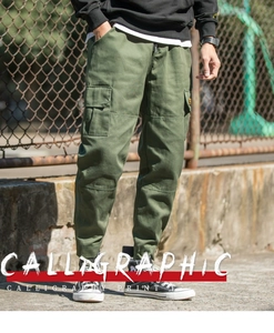 Detail of army green cargo pants featuring side flap pockets and cuffed leg openings