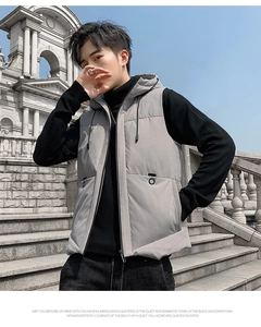 Detail view of light grey puffer vest with detachable hood and zipper on outdoor steps