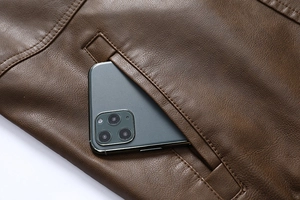 Detail of side pocket on brown leather jacket with reinforced stitching and pebble texture