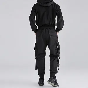 Vista posteriore della tuta techwear nera con pantaloni cargo e giacca tattica con cappuccio