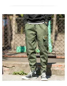 Detail of army green cargo pants with multi-pocket design and elastic tapered cuffs