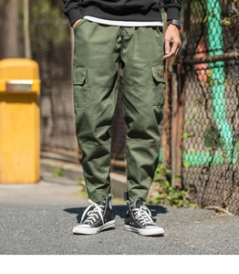 Detailed view of cargo pocket and durable cotton fabric on men's olive green joggers