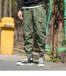 Detail view of army green cargo pants featuring side flap pockets and elastic drawstring waist