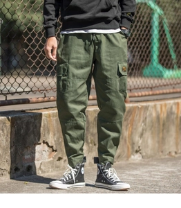 Detail view of army green cargo pants featuring drawstring waist and yellow side pocket label