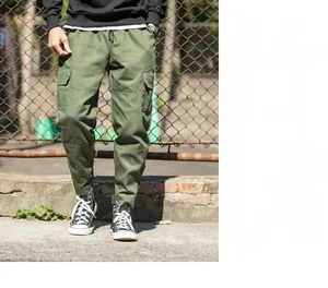 Detail of army green cargo pants featuring drawstring waist and large side flap pockets