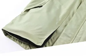 Macro view of functional olive green jacket featuring large tactical 3D side pockets