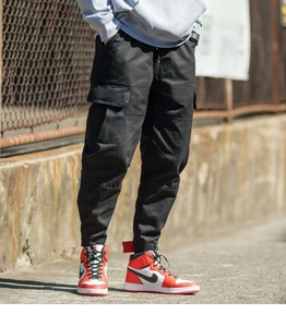 Men's black cargo pants with large side pockets and elastic cuffs for a casual street style