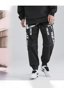 Detail of black techwear cargo pants featuring utility pockets and street style ribbons