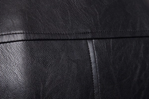 Macro shot of high-quality lychee texture black leather with durable reinforced double stitching