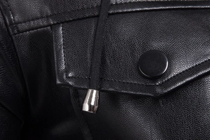 Macro detail of black leather texture with polished metal drawstring tip and snap button