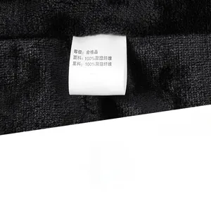 Close-up of black fleece texture and care label showing 100% polyester fabric details