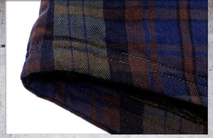 Close-up of thick flannel plaid shirt showing navy blue check pattern and double stitching