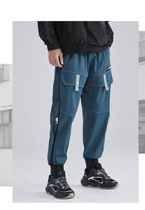 Detail of dark blue cargo joggers featuring white contrast stitching and side zip pockets