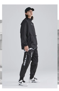 Detail of black technical outdoor set featuring functional cargo pants and hooded jacket