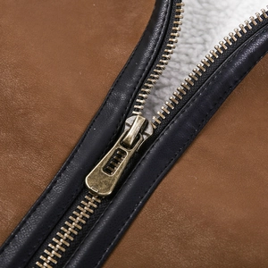 Detailed close-up of heavy-duty bronze zipper and warm white fleece lining on leather jacket