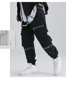 Detail of black techwear cargo pants with fashion ribbon and functional side pockets