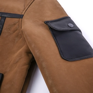 Detail of faux suede texture with leather flap pockets and stitching on the jacket sleeve
