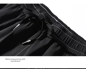 Close-up of black cargo pants featuring elastic waistband and metal tip drawstring