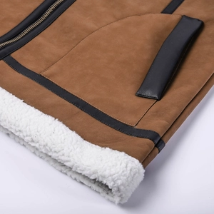 Macro detail of men's brown suede jacket with white shearling lining and metal zipper