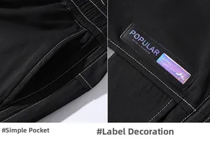 Macro detail of techwear pants with white stitching and laser-reflective logo patch
