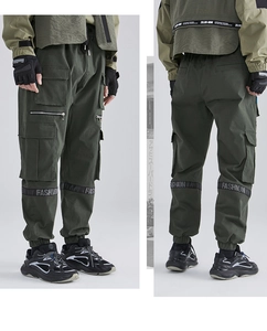 Detail of dark green cargo pants featuring functional pockets and stylish ribbon straps