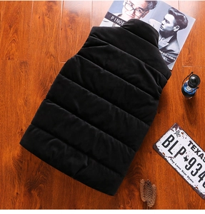 Rear view of black quilted puffer vest with stand-up collar on a rustic wood background