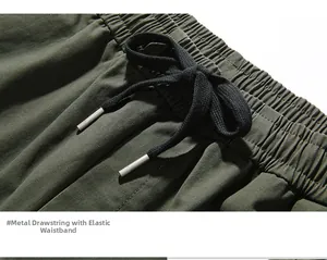 Macro detail of olive cargo pants featuring elastic waist and premium metal drawstring caps