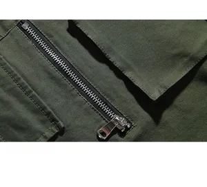 Detail of silver metal zipper pocket on military green cargo pants with canvas texture