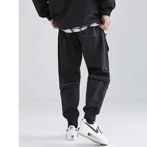 Men's black cargo jogger pants featuring white contrast stitching and side zipper pockets