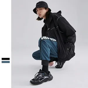 Men's functional techwear set featuring black hooded windbreaker and blue cargo joggers