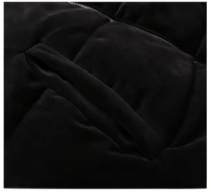 Detail shot of a black quilted puffer vest showing side button pocket and fabric texture