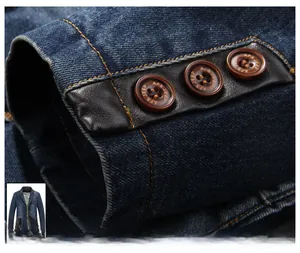 Detailed close-up of denim jacket cuff with brown vintage buttons and leather trim