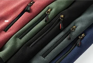 Detail view of polar fleece vests in burgundy, green, and navy with zipper pockets