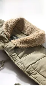 Close-up of army green pilot jacket with off-white faux shearling collar and stitching