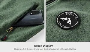 Detail of green fleece vest featuring a zippered pocket and embroidered mountain badge