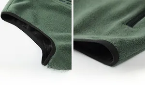 Detailed close-up of green fleece vest fabric with professional black hem stitching and seams