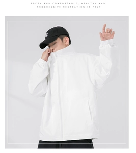 Detail shot of oversized white zip-up jacket with stand collar and elastic cuffs