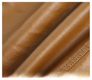 Detailed macro view of brown PU leather texture and premium stitching on a winter jacket