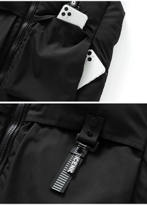 Détail d'un gilet d'hiver noir avec grande poche fonctionnelle contenant un smartphone