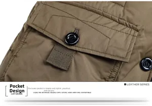 Detail of winter jacket pocket with durable button closure and reinforced webbing strap