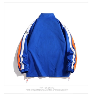 Detailed back view of a blue windbreaker with white and orange stripes and sport badge