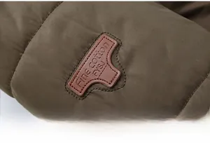 Close-up of quilted winter jacket fabric with embossed leather brand patch and fine stitching