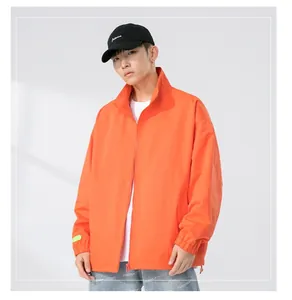 Detail of a bright orange men's jacket with elastic cuffs and a high collar design